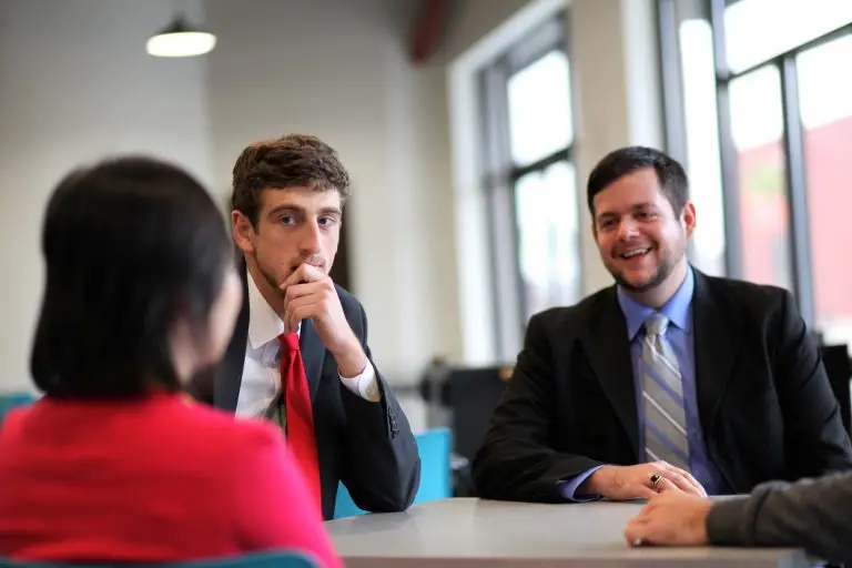 Two professionals meeting with a client at a table.